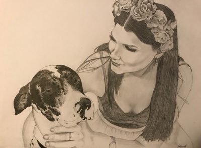 Graphite pencil portrait of a woman in a flower crown gazing at the black-and-white dog she is hugging